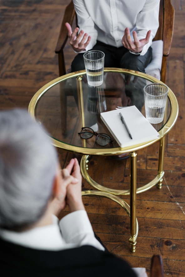 deux personnes discutent autour d'une table basse