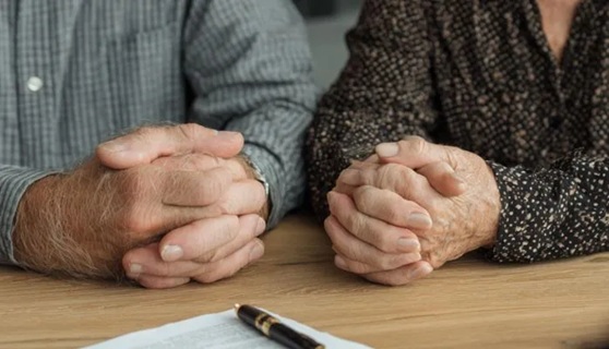 deux personnes âgées signent un document